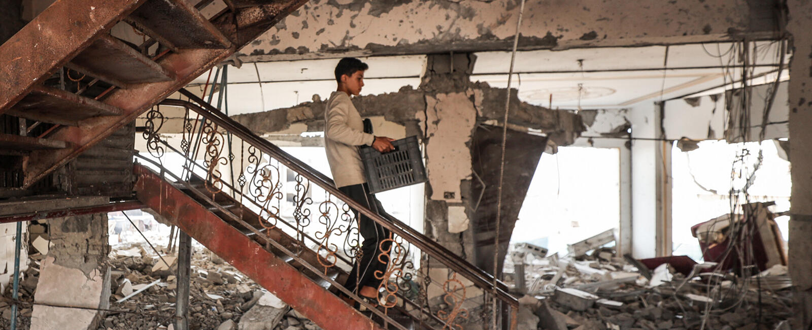 A boy walking down a staircase in a bombed-out apartment building in Khan Yunis.